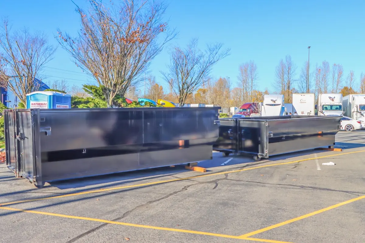 Professional dumpster rental service with roll-off container on residential driveway in Spring Arbor